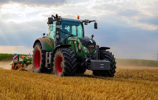 Green tractor plowing the fields