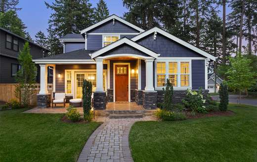 Home with manicured lawn backdrop trees