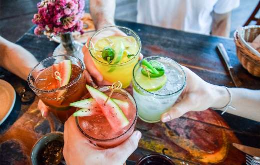 Friends toasting tropical blended fruits online