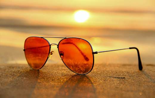 Red lens sunglasses on sand