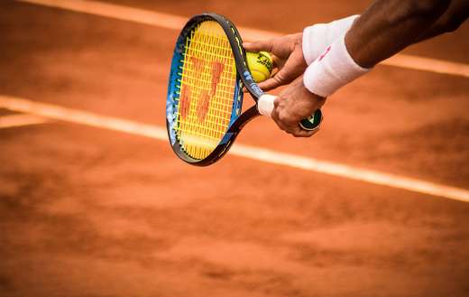 Person holding tennis racket ball